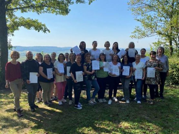 Gruppenbild im Freien von AbsolventInnen eines Kurses der Diakonie Württemberg.