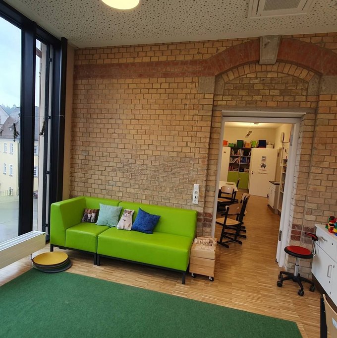 Es ist ein Raum zu sehen mit einer alten Steinernen Wand.