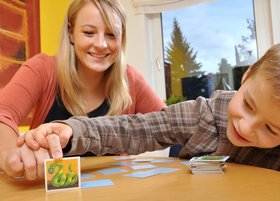 Eine junge Frau die mit einem Jungen Memorie spielt