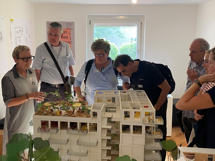 Bild zeigt wie mehrere Personen das Modell des Quartieres anschauen 