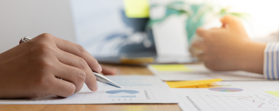 Das Bild zeigt zwei Hände die eine davon mit einem Stift in der Hand in einer Beratungssituation