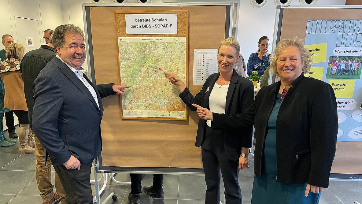 Bild zeigt drei Personen die auf eine Landkarte zeigen