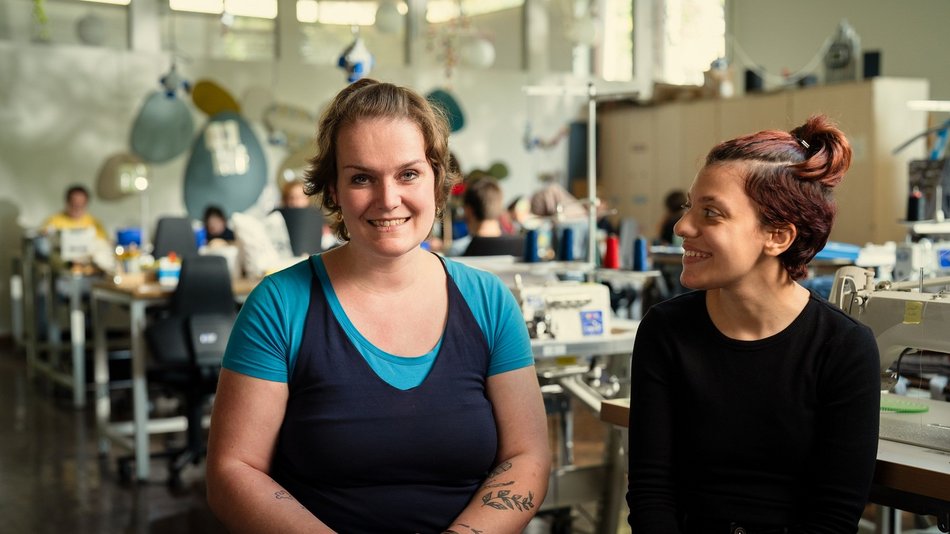 Bild zeigt Lisa und eine weitere Person in der Näherrei