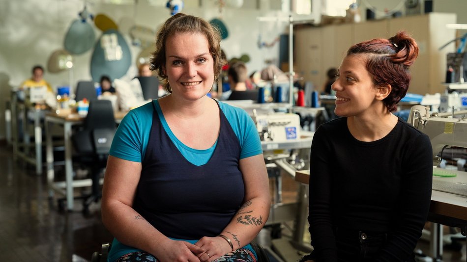 Bild zeigt Lisa und eine weitere Person in der Näherrei