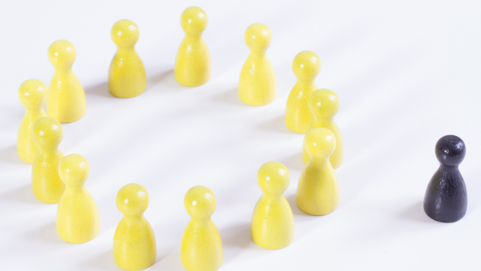 Mehrere gelbe Spielsteine bilden einen Kreis und außerhalb des Kreises steht ein schwarzer Spielstein.