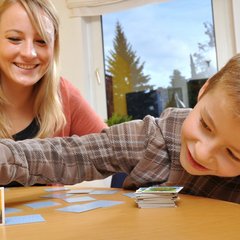 Eine junge Frau die mit einem Jungen Memorie spielt