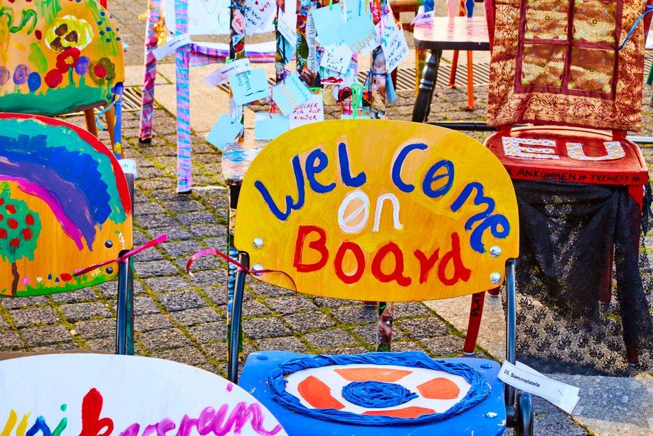 Bild zeigt einen bunt bemalten Stuhl mit der Aufschrift "WelCome on Board"