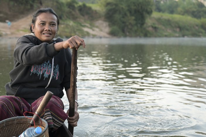 Bild zeigt eine Mann in einem Boot auf dem Fluss, er hat ein Paddel in der Hand