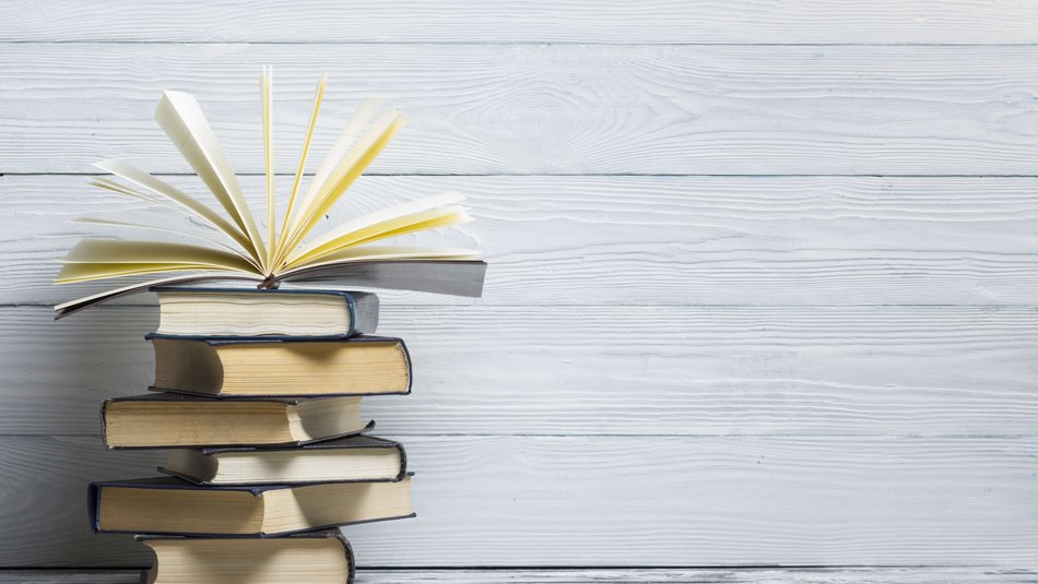 Ein Stapel aus sechs Büchern, das oberste ist aufgeklappt.