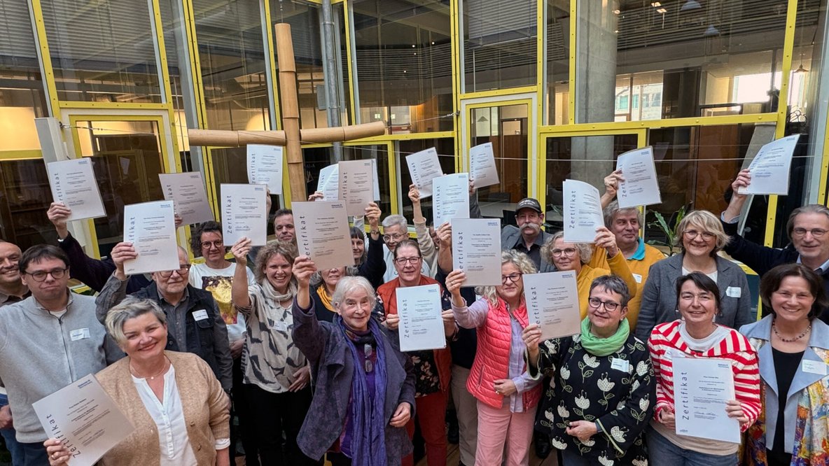 Gruppenbild der AbsolventInnen des Andachtskurs der Diakonie Württemberg. Alle halten ihre Urkunde hoch in die Kamera.