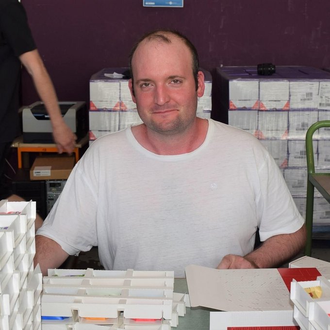 Es ist ein Mitarbeiter zu sehen, welcher den Schoko-Inhalt in die Verpackung packt.