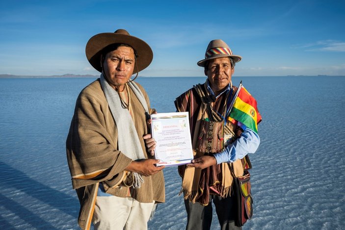Bild zeigt zwei Männer mit einer Urkunde die am Meer stehen