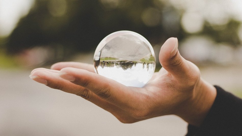 Bild zeigt eine Hand die eine Glaskugel hält