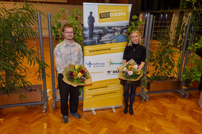 Bild zeigt die Gewinner mit einem Blumenstrauß in der Hand