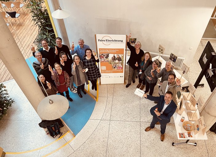 Bild zeigt eine Abordnung bei der Übergabe der Plakette in der Landesgeschäftsstelle im Foyer von oben