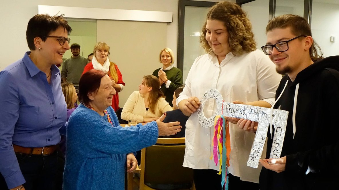 Bild zeigt vier Personen bei der Symbolischen Schlüsselübergabe
