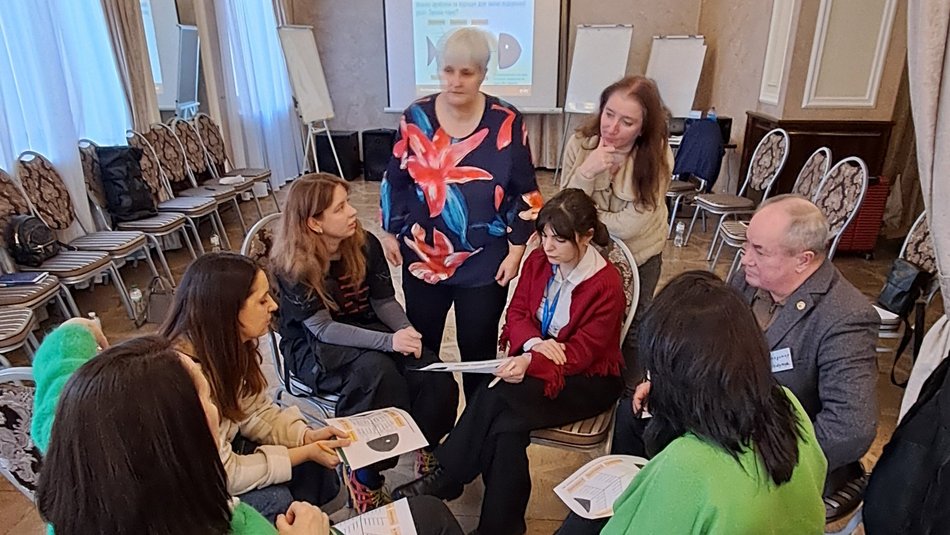 Bild zeigt eine Gruppe die einen Stuhlkreis sitzt