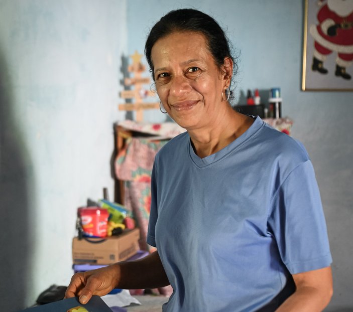 Bild zeigt eine lächelnde Frau aus Kolumbien in ihre Wohnung