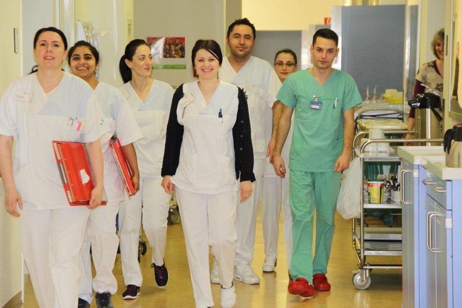 Bild zeigt eine Gruppe von Pfeger:innen bei der Visite in einem Krankenhaus