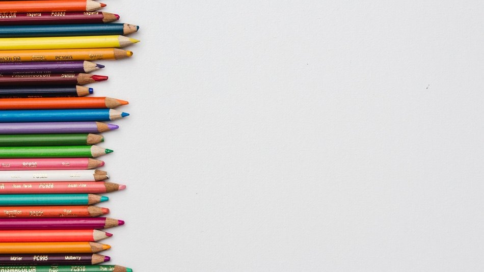 Verschiedene Buntstifte liegen untereinander links im Bild.