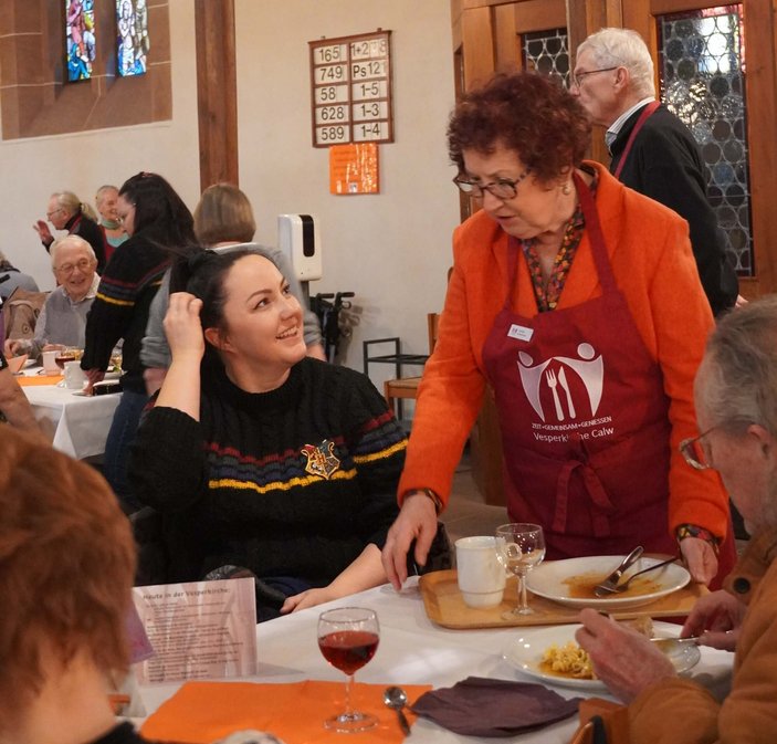 Bild zeigt eine Frau beim Tische abräumen