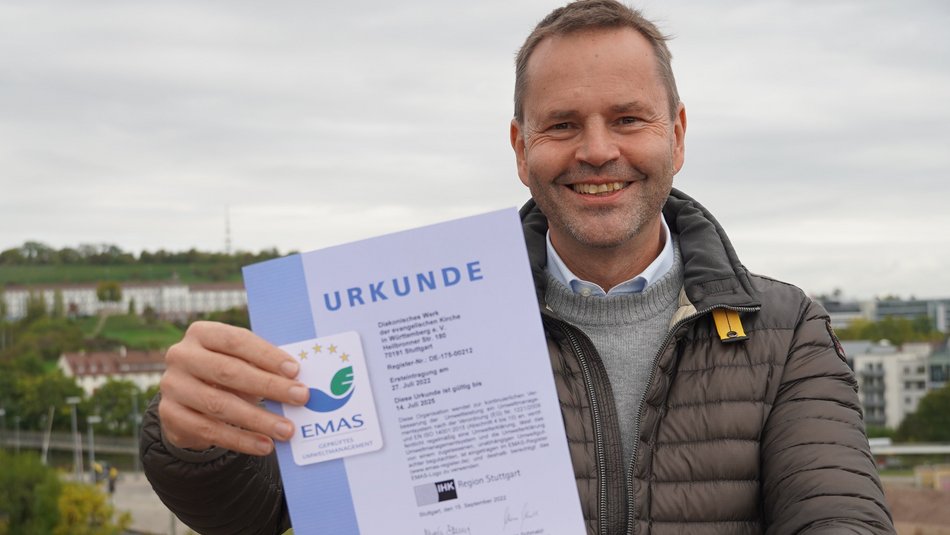 Bild zeigt Herr Bachert mit der Urkunde in der Hand auf dem Dach der Landesgeschäftsstelle stehen