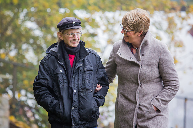 Bild zeigt eine Frau die einen Mann beim spazieren gehen führt