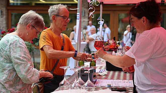 Zwei Menschen kaufen Wein an der Bar.