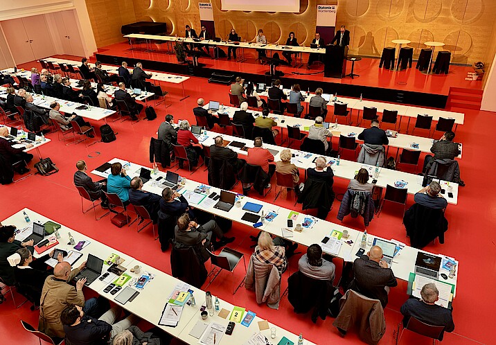 Blick von oben: Im großen Saal des Hospitalhofs sitzen viele Menschen mit Laptops an Tischen, auf der Bühne sitzen die Vorstands- und Präsidiumsmitglieder des DWW.