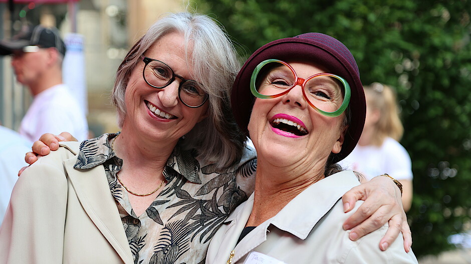 Vorstandsvorsitzende Dr. Annette Noller (l.) mit Kabarettistin Sabine Schief alias "Hildegard" lachen in die Kamera.