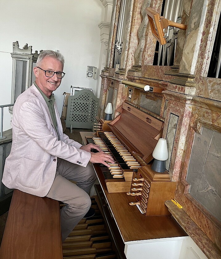 Hans-Jürgen Kaiser sitzt an einer Orgel.