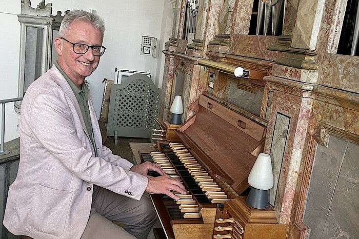 Hans-Jürgen Kaiser sitzt an einer Orgel.