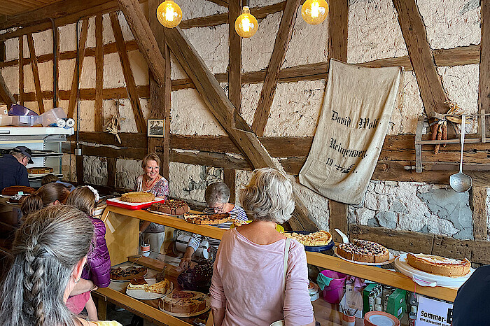 Menschen stehen an einer Kuchentheke in der Burg.