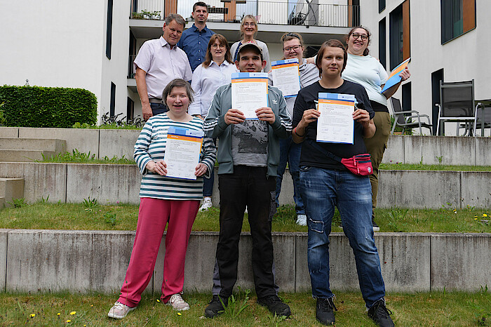 Die Teilnehmenden des Quali-Bausteins der Mariaberger Werkstätten stehen mit Zertifikaten vor dem Gebäude.