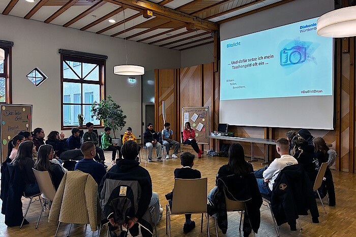Jugendliche sitzen in einem Stuhlkreis